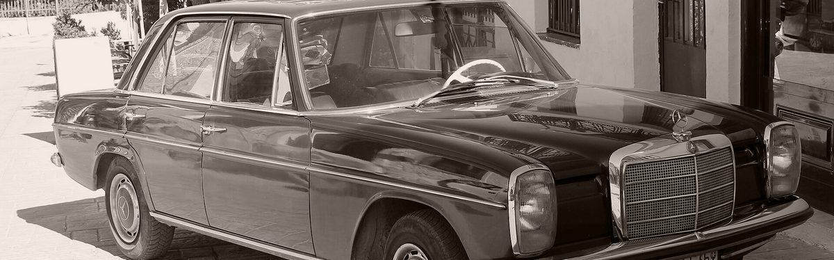 An older Mercedes-Benz sedan parked on a street