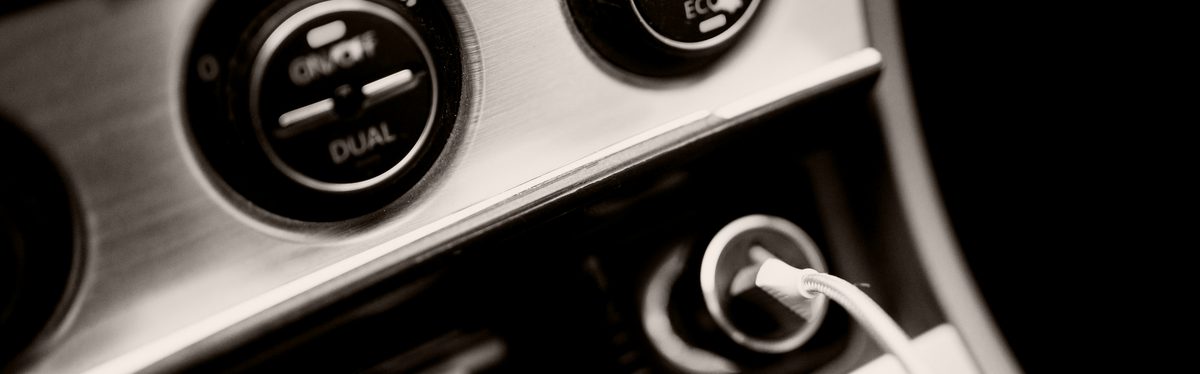 Close-up of a car dashboard with dual-zone climate control knobs lit at night