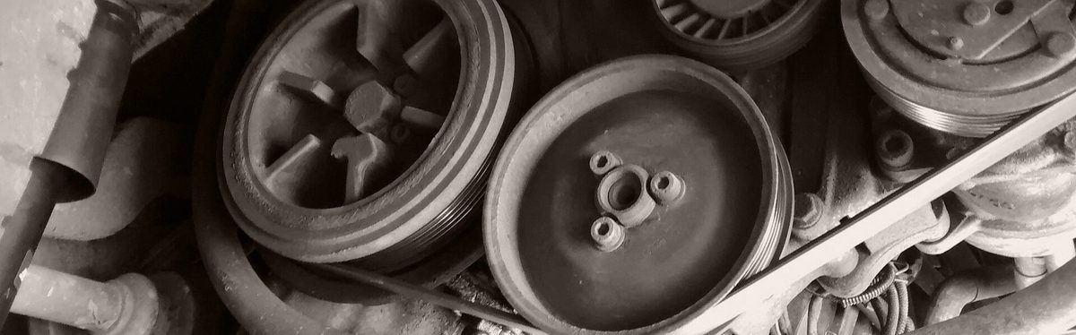 Drive belt pulleys and a tensioner on the front of an engine