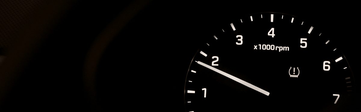 A car tachometer with a warning lamp lit beside it