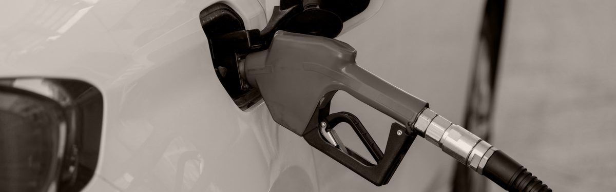 A fuel nozzle in a car's filler neck at a gas station