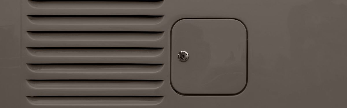A locking fuel filler door on a van panel, beside a row of pressed louvres