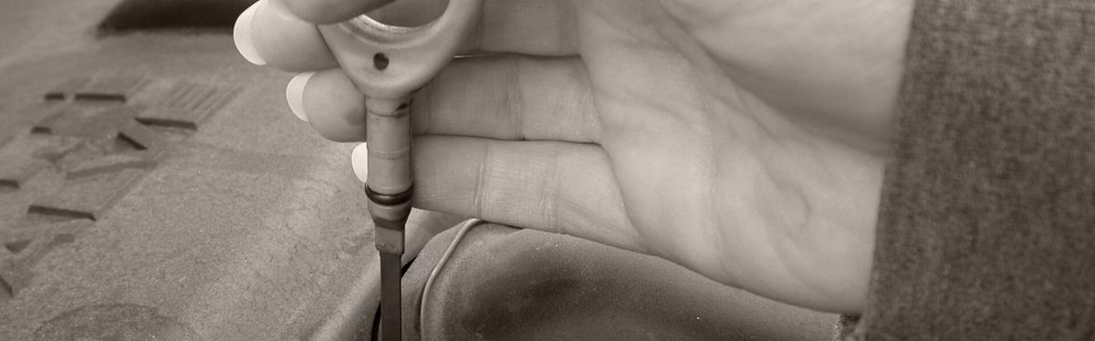 An engine oil dipstick pulled from its tube