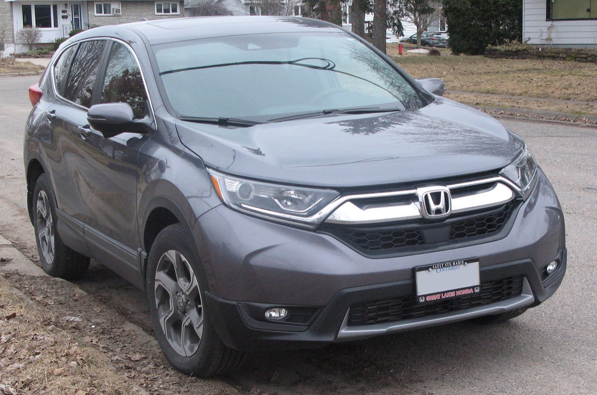 A fifth-generation Honda CR-V photographed from the front three-quarter, parked at a curb