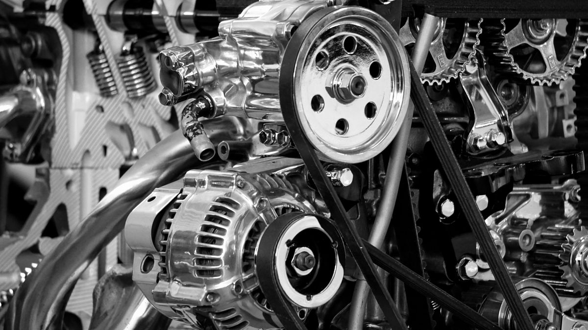An alternator low on an engine with the serpentine belt wrapped around its pulley