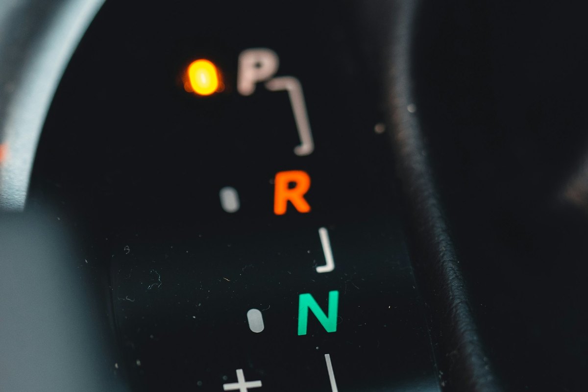 Close-up of an automatic gear selector display: an amber lamp beside P, R in orange and N in green