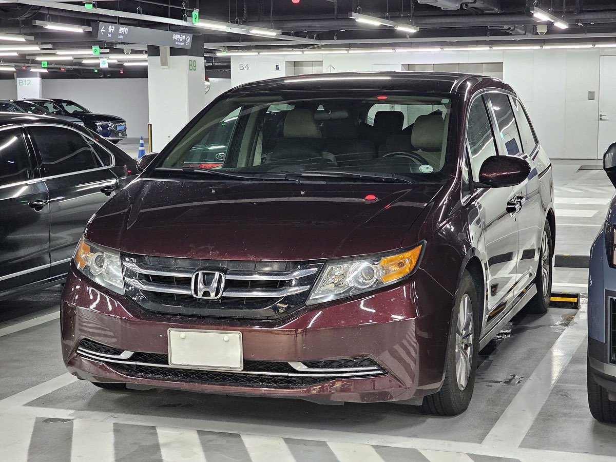 A Honda Odyssey minivan of the 2011 to 2017 generation, parked, seen from the front three quarters