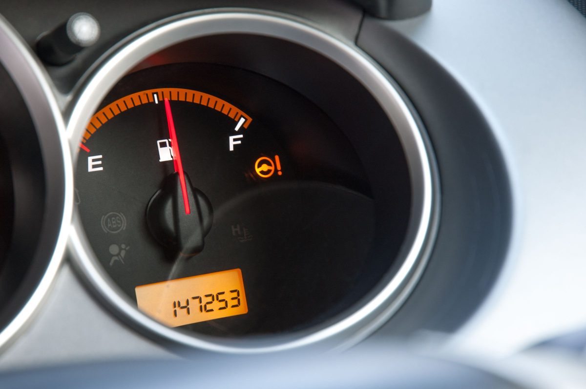 Car instrument cluster close-up, the odometer reading 147,253 miles beside the fuel gauge
