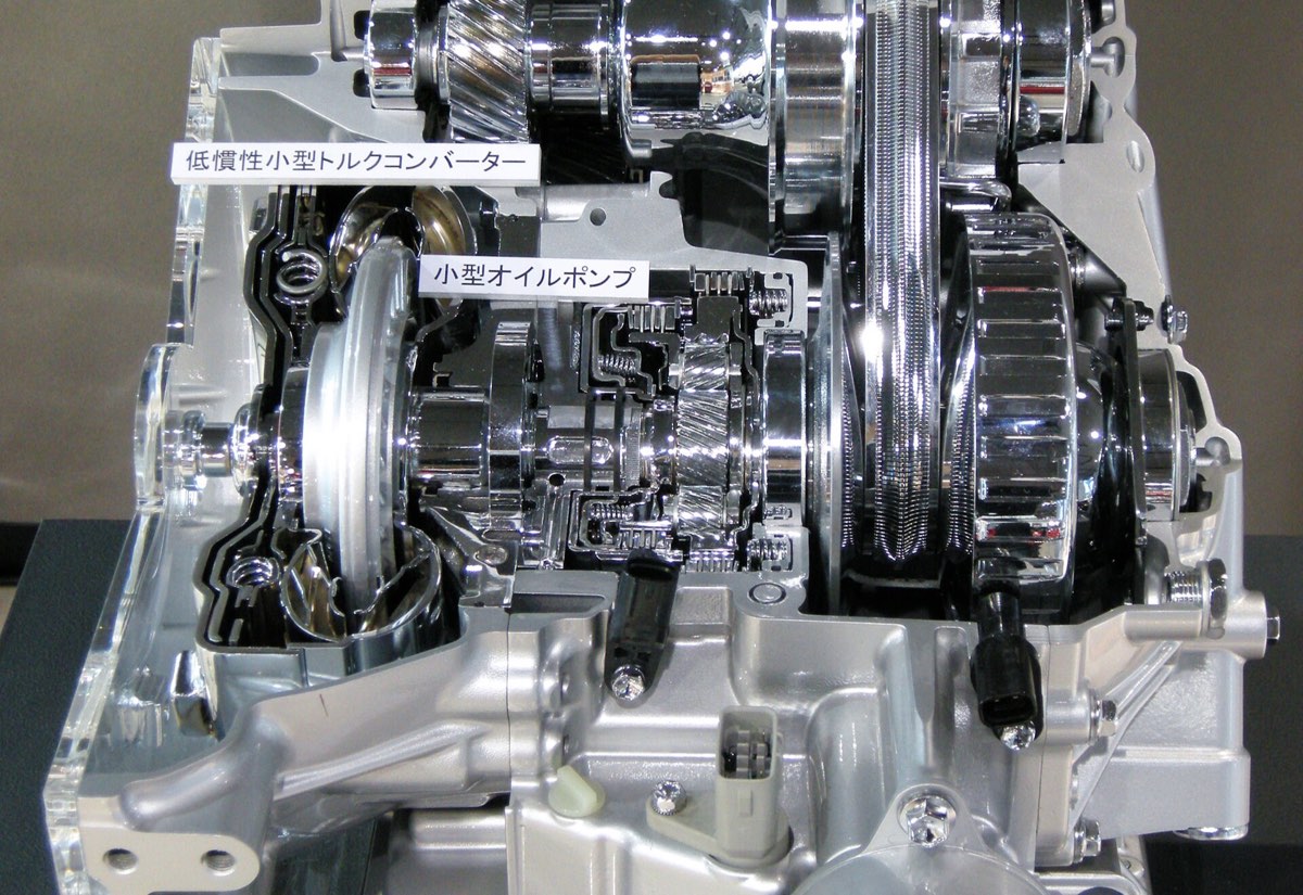 A sectioned CVT with the steel belt running between its two pulleys, torque converter and oil pump cut open beside it