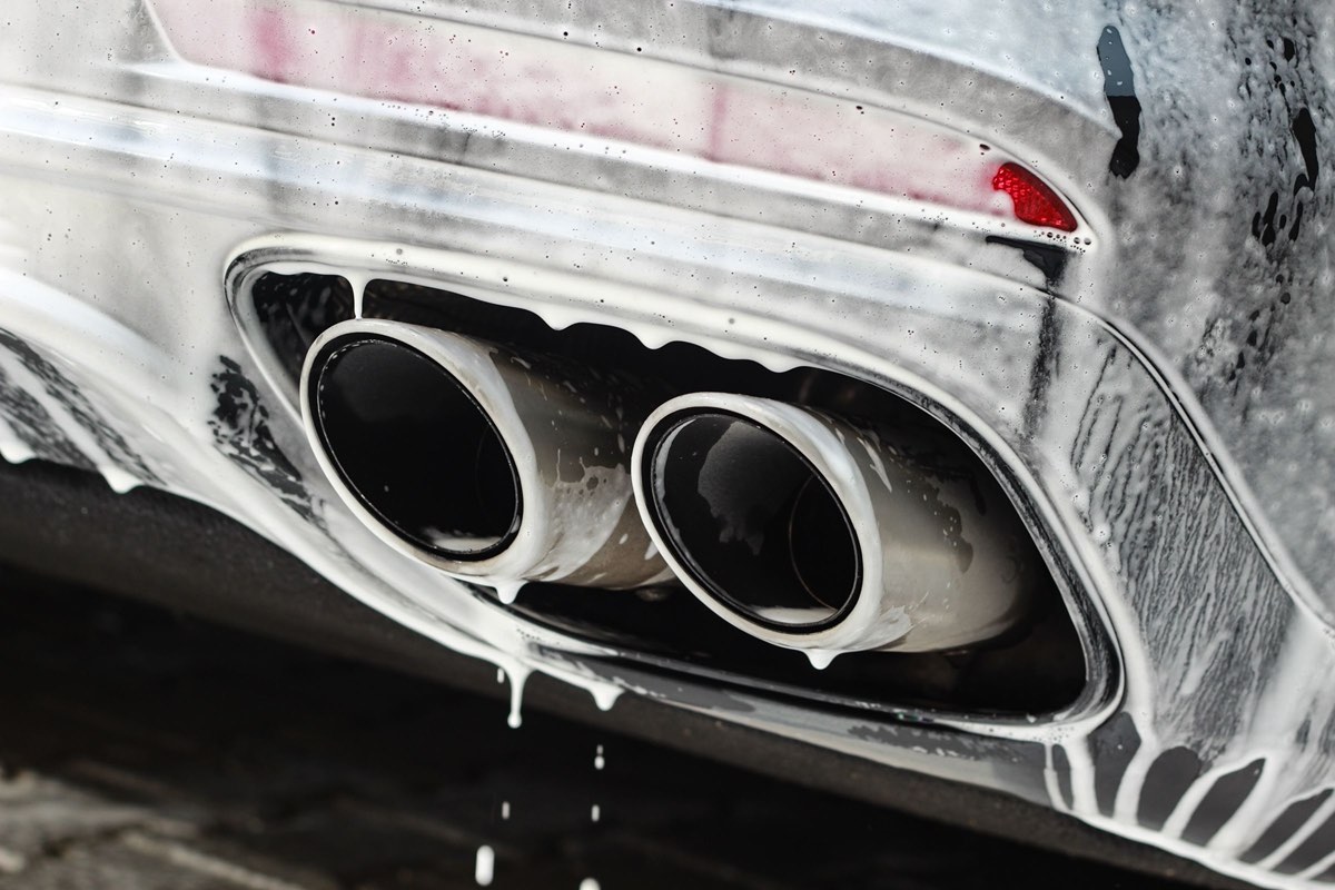 The twin exhaust tips of a late-model car, the kind still young enough for the federal converter warranty to apply.